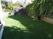 Artificial grass and veneer stone retaining wall for a backyard in San Francisco, California.